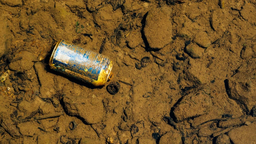 a can that is sitting in the dirt, a photo, unsplash, surface with beer-texture, subsiding floodwaters, 15081959 21121991 01012000 4k, contaminated