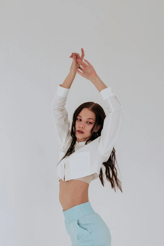 a woman in a white shirt and blue skirt, an album cover, unsplash, bella poarch, wearing a cropped tops, at a fashion shoot, arms extended