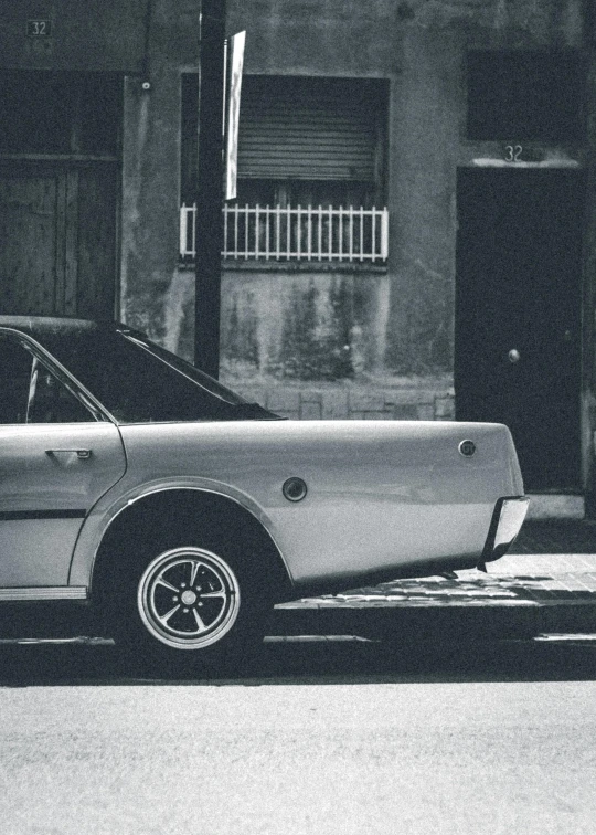a black and white photo of a car parked in front of a building, an album cover, pexels contest winner, palermo city street, profile image, 1980 cars, mustang