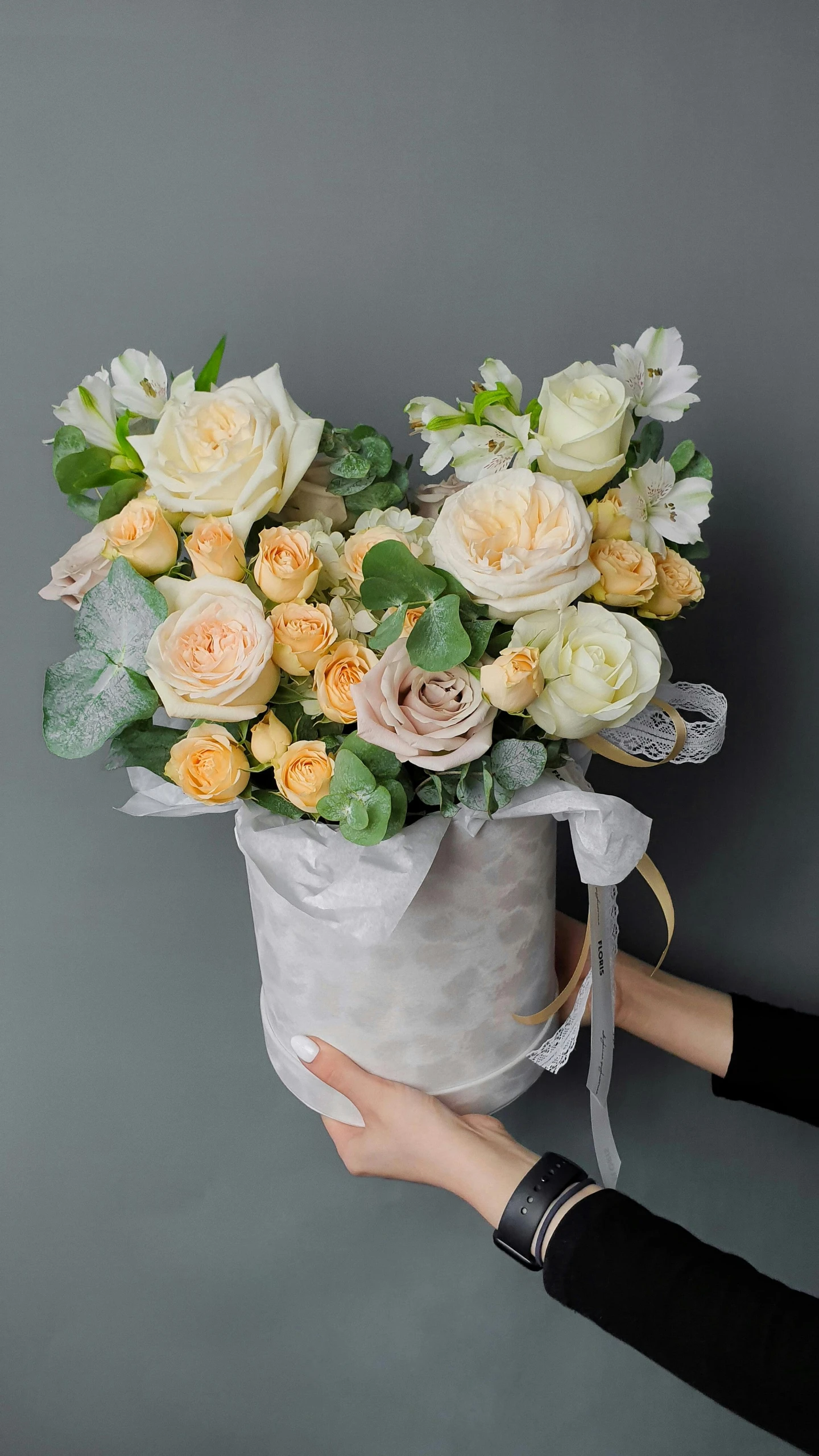 a woman holding a bouquet of flowers against a wall, inspired by François Boquet, pexels, silver and yellow color scheme, crown of peach roses, on a gray background, cream and white color scheme