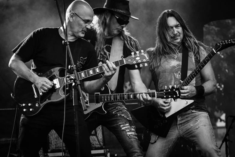 a group of men playing guitars on a stage, a picture, sots art, caparison, playing a gibson les paul guitar, profile image, stern look