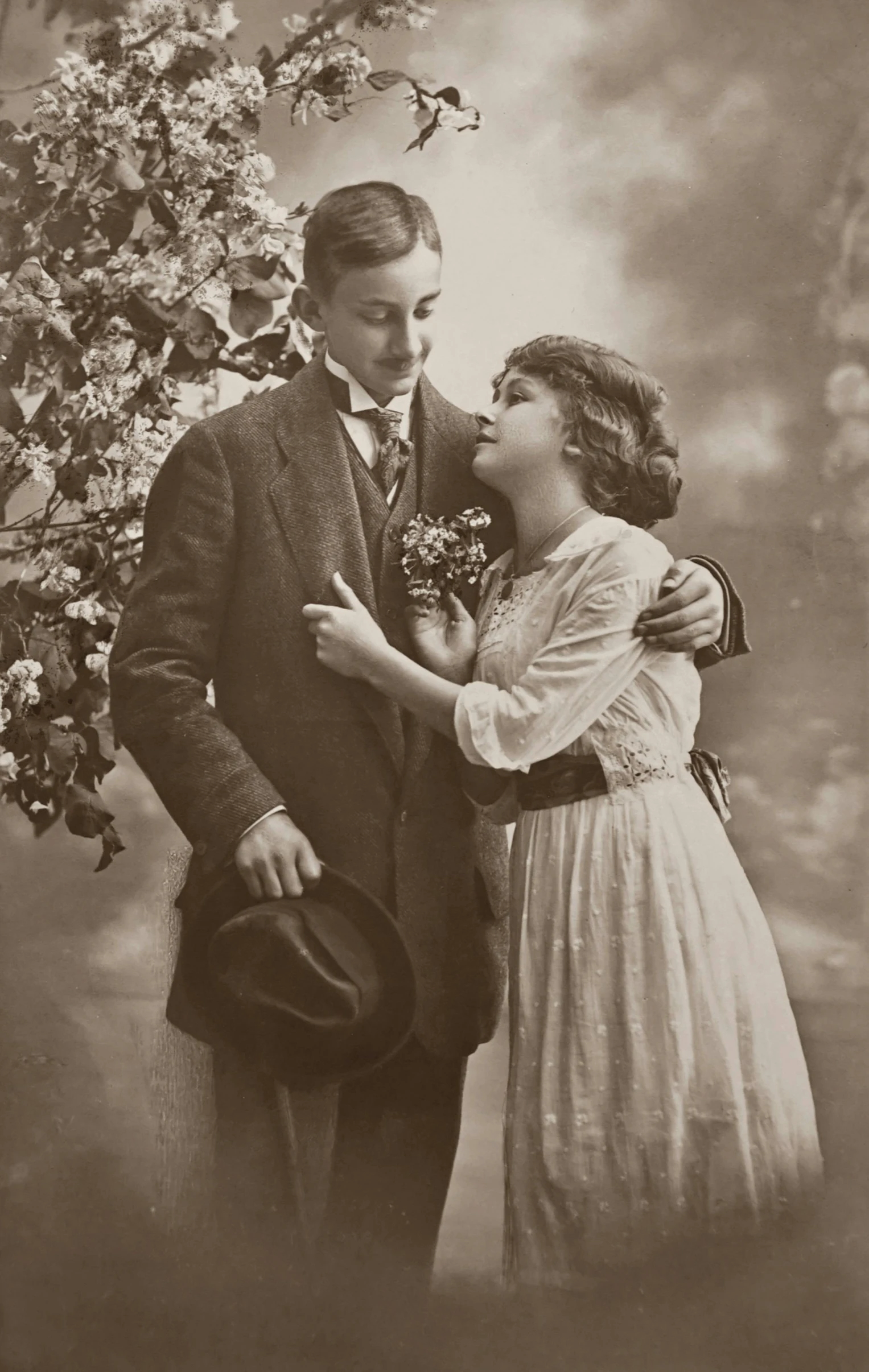 an old black and white photo of a man and a woman, a colorized photo, by Lucia Peka, art nouveau, teenage boy, victorian inspired clothing, 35mm —w 1920 —h 1080, kiss