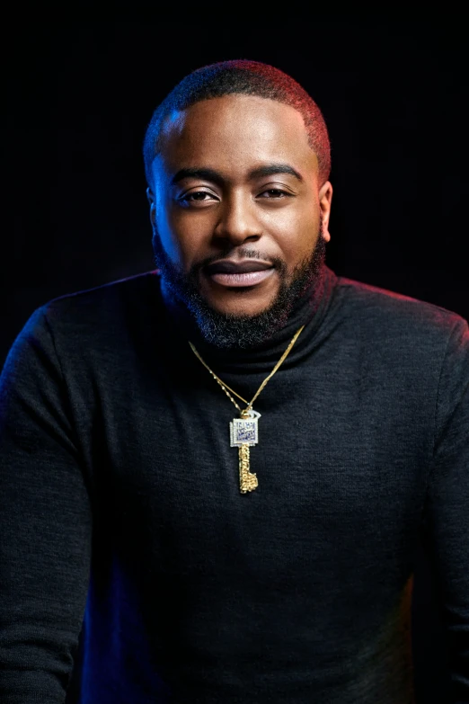 a man in a black sweater posing for a picture, an album cover, inspired by Michael James Smith, trending on pexels, rapper bling jewelry, mkbhd, timothy rees, headshot portrait