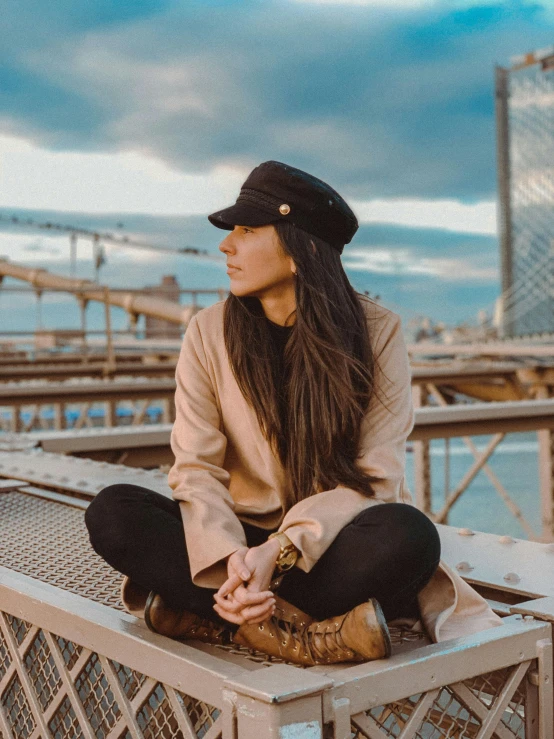 a woman sitting on top of a metal bench, profile image, beige fedora, pokimane, 🚿🗝📝
