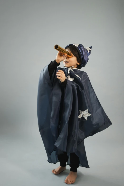 a little boy dressed up as a wizard, an album cover, by Helen Stevenson, pexels contest winner, telescope, on a gray background, high quality theatre costume, magic star