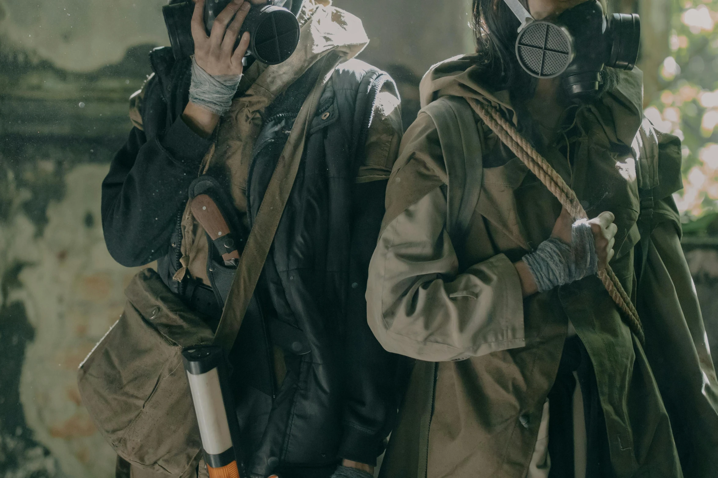 two people in gas masks standing next to each other, inspired by ashley wood, trending on unsplash, trench coat with many pockets, ismail inceoglu and ruan jia, [ theatrical ], carrying survival gear