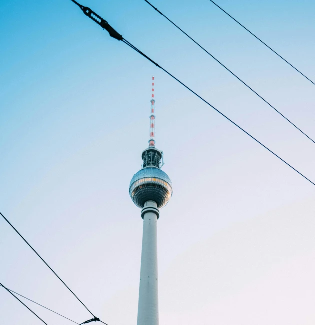 a tall tower sitting in the middle of a city, pexels contest winner, berlin secession, electric cables, long neck, midcentury modern, dominant wihte and blue colours