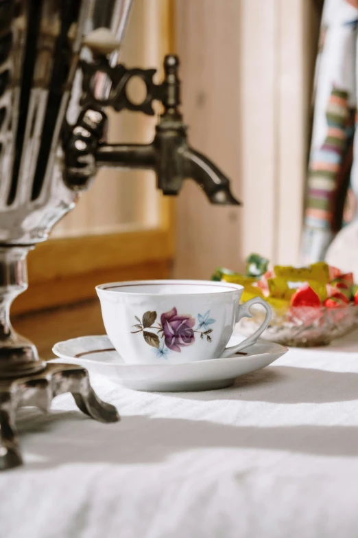 a tea cup and saucer sitting on a table, inspired by Judy Takács, romanticism, indoor scene, deluxe, on a table, mix