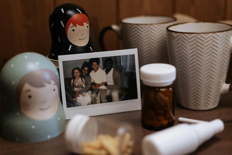 a couple of mugs sitting on top of a table, a polaroid photo, inspired by Diane Arbus, portrait of family of three, candy hospital room, jar on a shelf, photo of a black woman