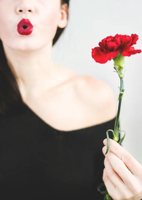 a woman holding a flower in front of her face, an album cover, trending on unsplash, romanticism, both have red lips, carnation, profile image, tall and thin