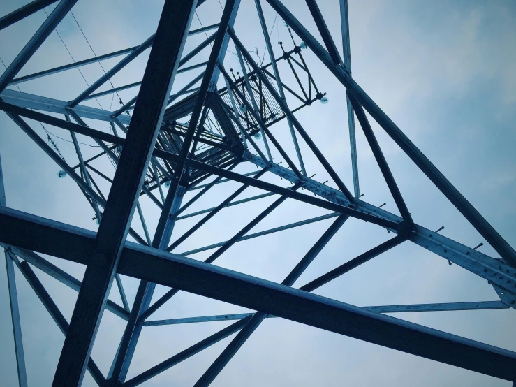 a high voltage tower with a blue sky in the background, by Carey Morris, unsplash, show from below, mechanical structure, dark and moody, instagram picture