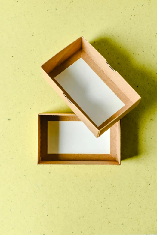 an open box sitting on top of a table, on yellow paper, business card, craft, deckle edge