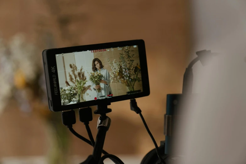 a cell phone sitting on top of a tripod, by Romain brook, trending on pexels, video art, lcd screen, female model, panavision millennium dxl 2, photoshoot for skincare brand