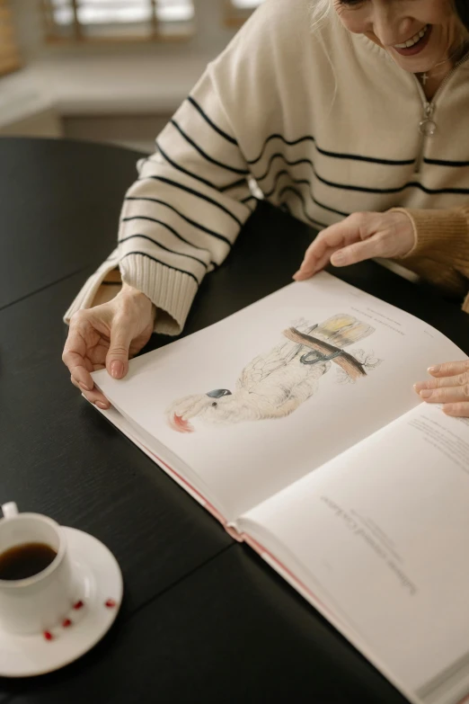 a woman sitting at a table reading a book, a drawing, by Ruth Simpson, pexels contest winner, anatomy book, casually dressed, age, gif