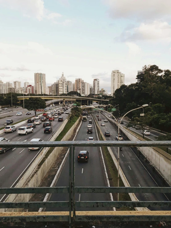 a highway filled with lots of traffic next to tall buildings, inspired by Thomas Struth, pexels contest winner, são paulo, 🐝👗👾, high bridges, subtitles