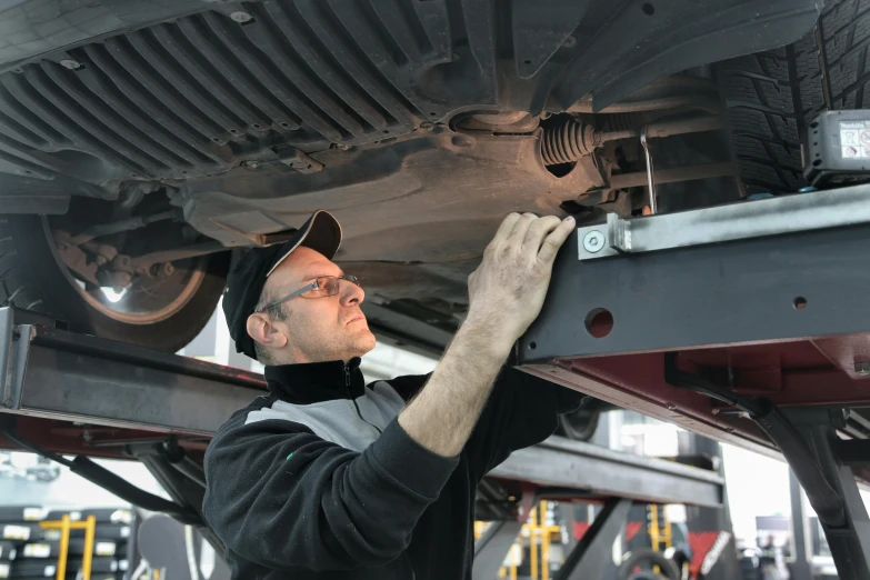 a man working on the underside of a vehicle, a photo, by Meredith Dillman, shutterstock, renaissance, 15081959 21121991 01012000 4k, avatar image, lachlan bailey, profile photo