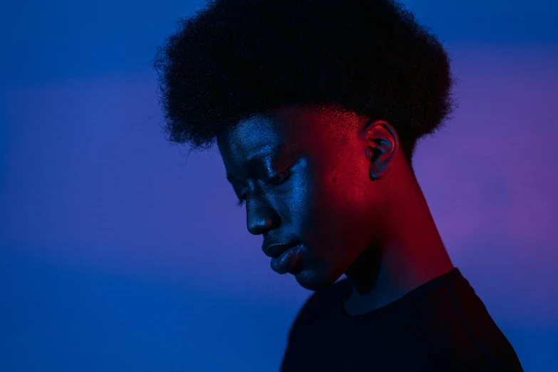 a close up of a person with a cell phone, by Adam Marczyński, pexels contest winner, afrofuturism, red and blue black light, black teenage girl, androgynous person, soft light from the side