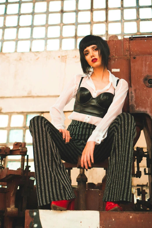 a woman sitting on top of a pile of luggage, an album cover, inspired by Elsa Bleda, trending on pexels, bauhaus, wearing a pinstripe suit, krysten ritter, ( steampunk ), leather pants