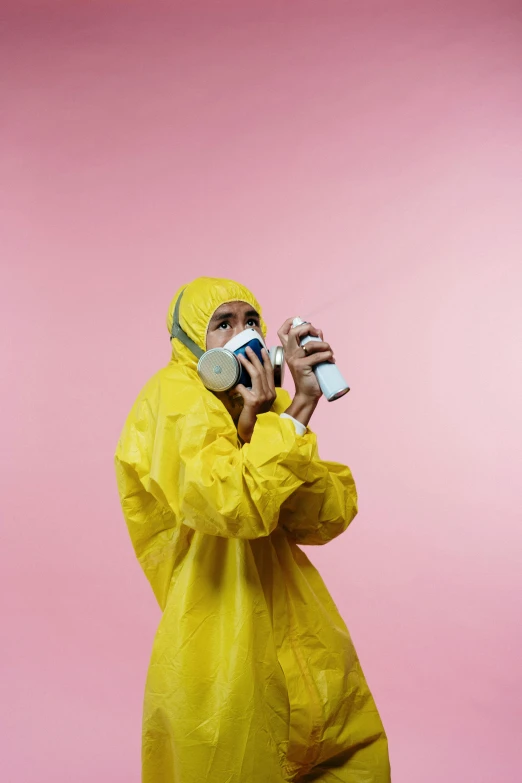 a man in a yellow hazmat suit talking on a cell phone, by artist, shutterstock, carrying a bottle of perfume, press shot, pink and yellow, surgical mask covering mouth