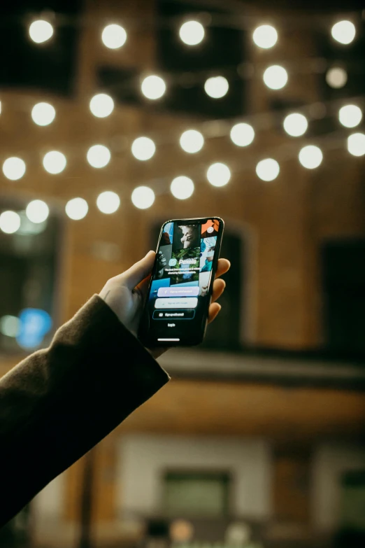 a person holding a cell phone up in the air, trending on pexels, night lights, lightly dressed, instagram influencer, everything fits on the screen