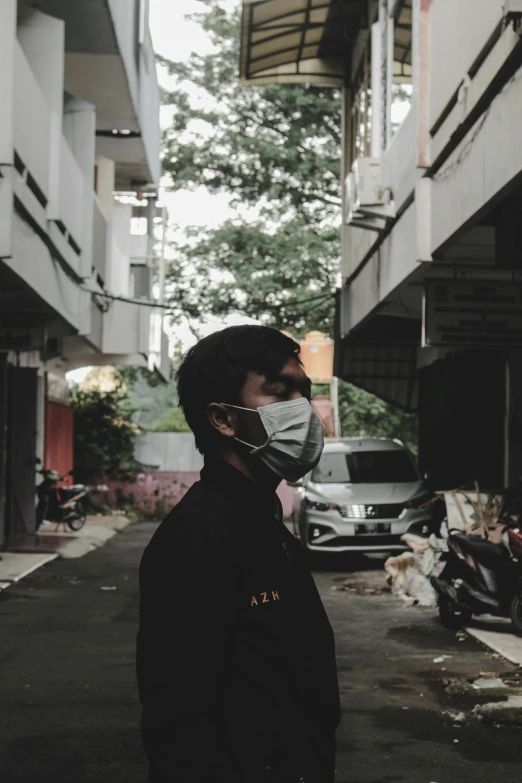a man wearing a face mask standing in an alley, a picture, jakarta, profile picture 1024px, album cover, chemistry