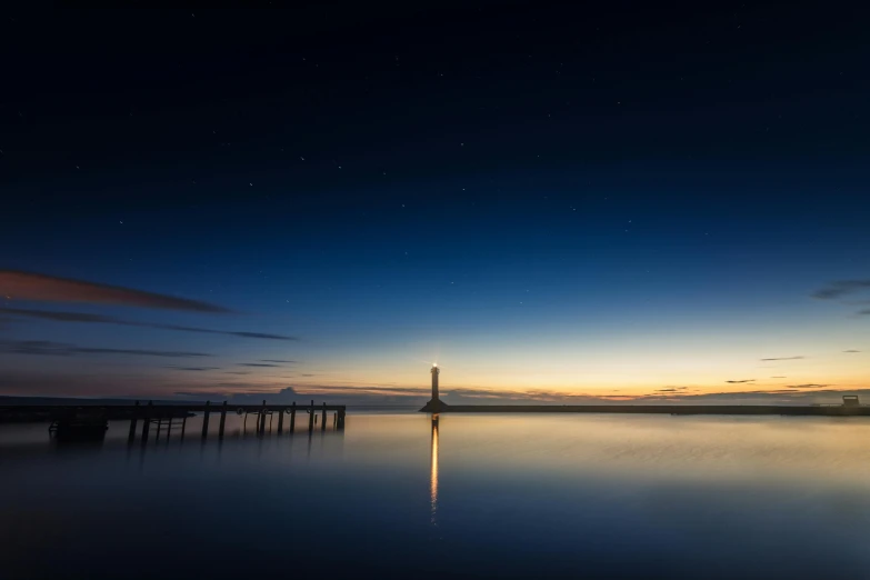 a lighthouse sitting on top of a body of water, by Eglon van der Neer, unsplash contest winner, celestial light, calm evening, spire, eight eight eight