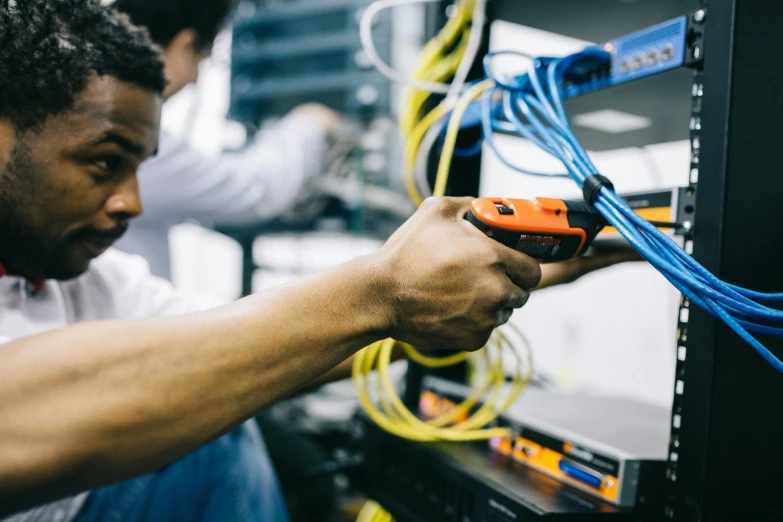 a man working on a server in a server room, by Carey Morris, pexels, worksafe. instagram photo, afro tech, electrical wiring!, handling laboratory equipment