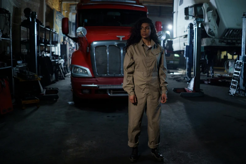 a woman standing in front of a red truck, a portrait, by Dan Frazier, pexels contest winner, renaissance, air force jumpsuit, spooky netflix still shot, in a workshop, charli bowater and artgeem