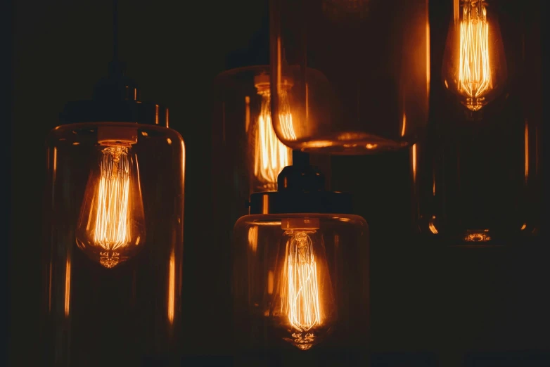 a group of light bulbs sitting on top of a table, pexels contest winner, light and space, amber glow, gothic lighting, warm lantern lighting, retro vibe