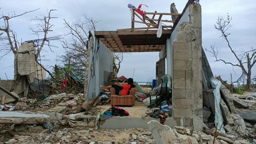 a woman sitting in a chair on top of a pile of rubble, after the storm, wētā fx, with furniture overturned, ruan ji