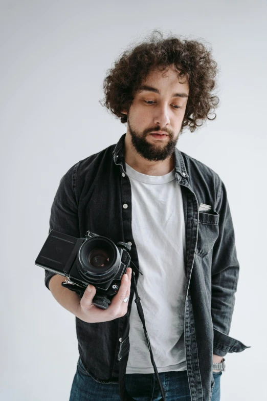 a man with curly hair holding a camera, outfit photograph, no - text no - logo, h3h3, professional photo-n 3