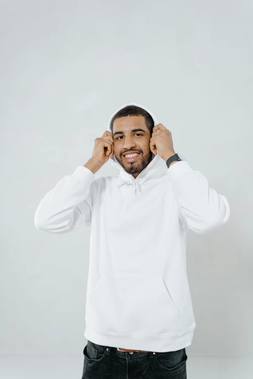 a man in a white hoodie posing for a picture, trending on pexels, earing a shirt laughing, luis melo, product introduction photo, very minimal