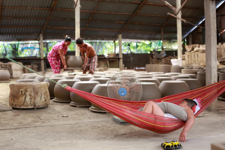 a woman laying in a hammock in a factory, hard clay, families playing, avatar image, shipibo