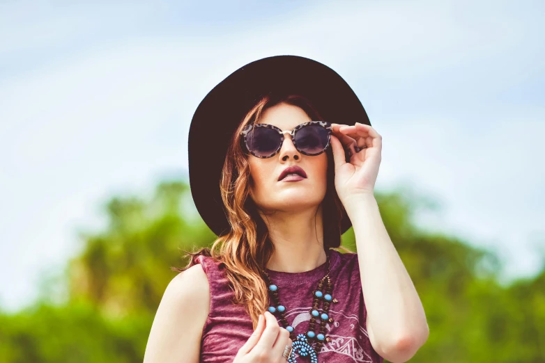 a beautiful young woman wearing a hat and sunglasses, by Joe Bowler, trending on pexels, aestheticism, lucy hale, vintage clothing, looking upwards, wearing a vest top