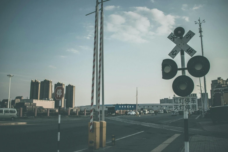 a railroad crossing signal sitting on the side of a road, by Karl Buesgen, pexels contest winner, baotou china, skyline, old signs