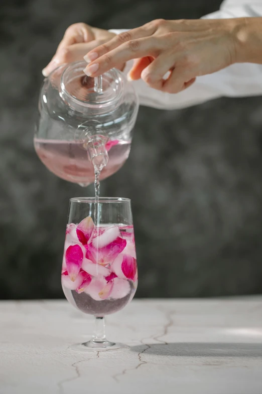 a person pouring water into a wine glass, large individual rose petals, botanicals, 4l, eora