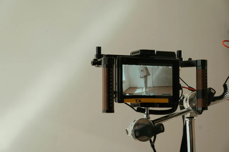 a close up of a camera on a tripod, video art, with backdrop of natural light, tv still frame, medium format camera, lcd screen