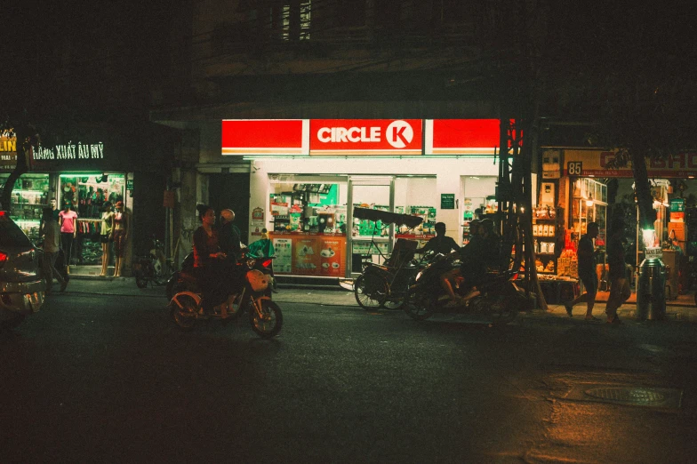 a group of people riding motorcycles down a street at night, pexels contest winner, convenience store, triangle inside circle, pharmacy, circles