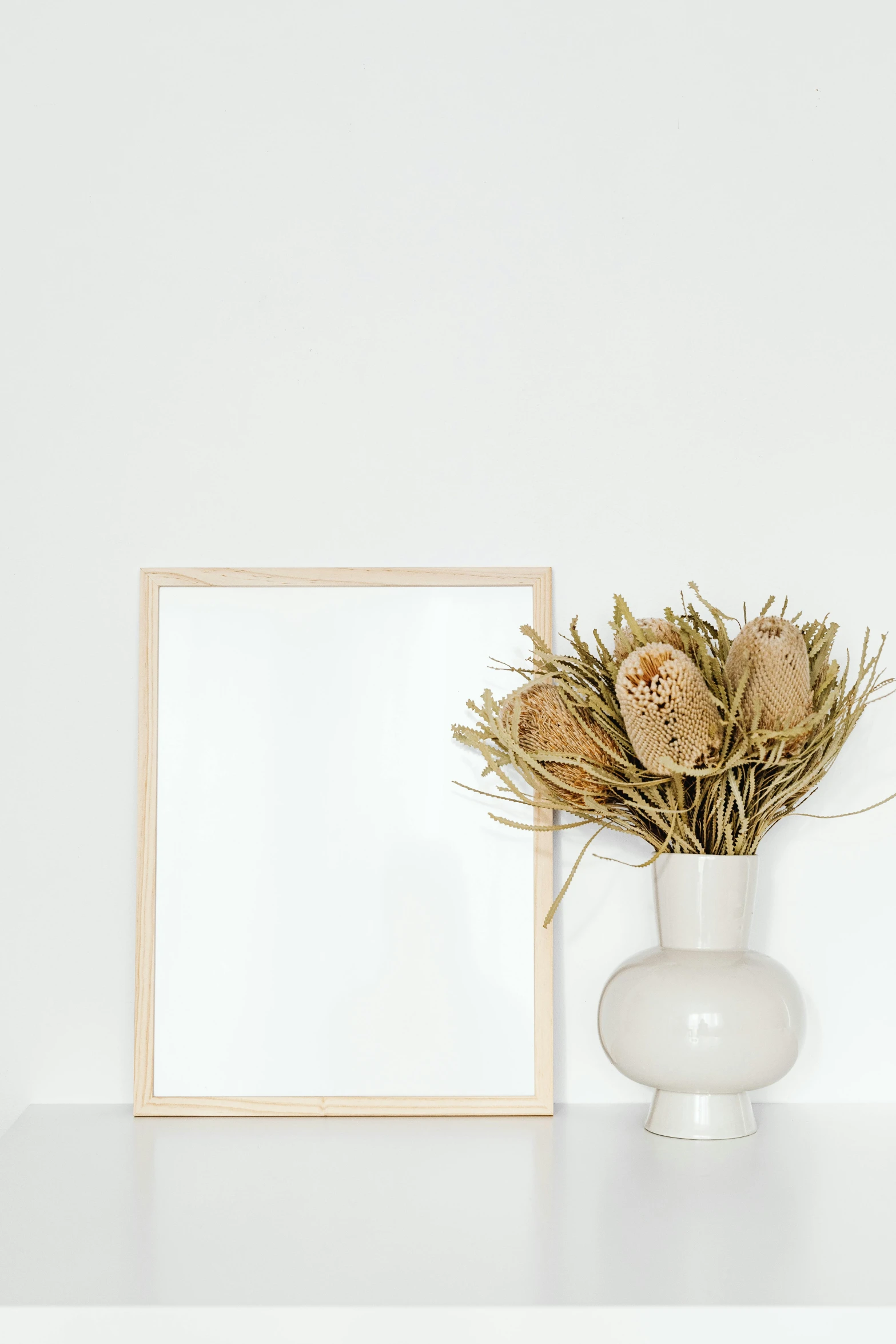 a picture frame sitting on top of a white shelf, pexels contest winner, vase with flowers, beige color scheme, product introduction photo, clean white background