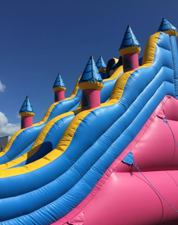 a pink and blue inflatable slide with a castle in the background, gay pride, they might be crawling, thumbnail, ladder
