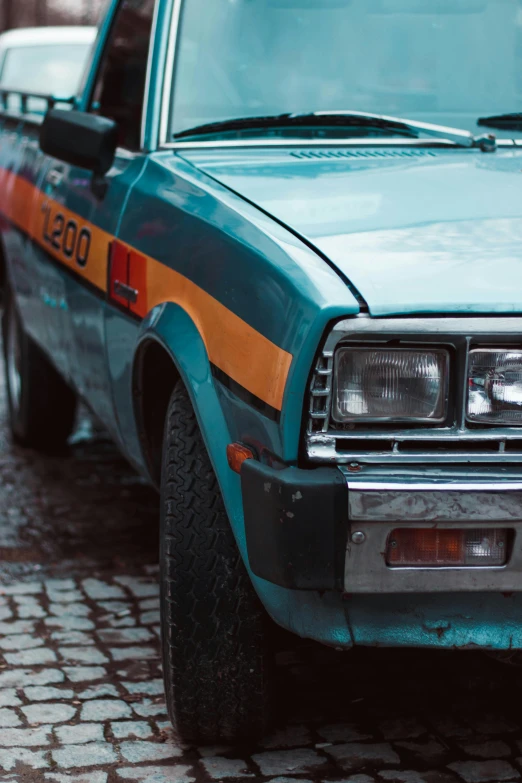 a car is parked on a cobblestone street, pexels contest winner, photorealism, striped orange and teal, 1 9 7 0 s car window closeup, police car lights, 🚿🗝📝