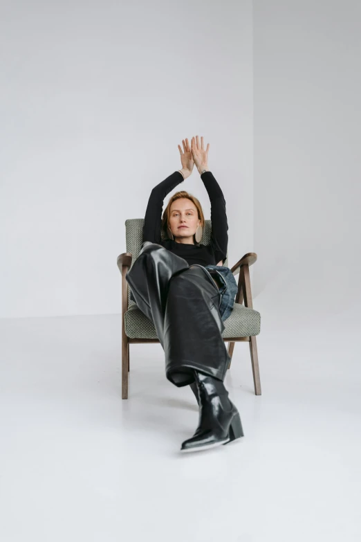 a woman sitting in a chair with her hands in the air, inspired by Anna Füssli, renaissance, leather and suede, curated collection, confident, greta thunberg