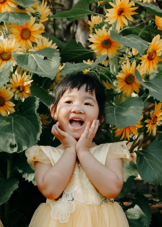 a little girl standing in front of a bunch of sunflowers, inspired by Xie Sun, pexels contest winner, laughing hysterically, mai anh tran, covered in vines, young cute wan asian face