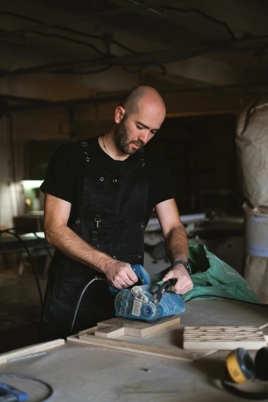 a man sanding a piece of wood in a workshop, a portrait, inspired by david rubín, pexels contest winner, lachlan bailey, avatar image, plating, profile image