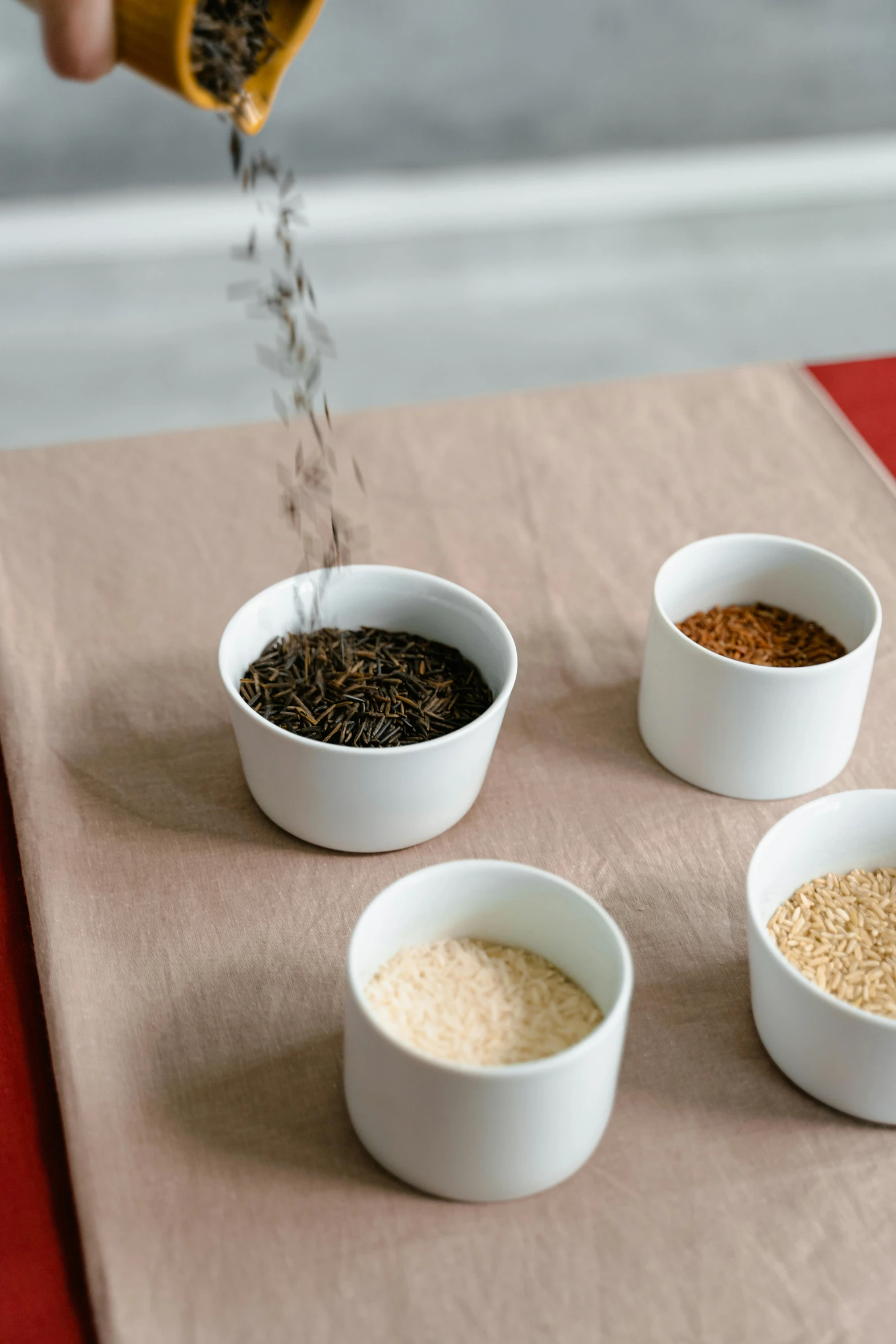 a person sprinkles seeds into small white bowls, inspired by Kanō Shōsenin, kinetic pointillism, spices, detailed product image, tall shot, square