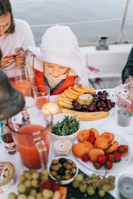 a group of people sitting around a table filled with food, fruits, on a boat, midsommar color theme, profile image