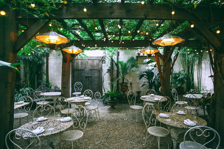 an outdoor dining area with tables and chairs, by Carey Morris, new orleans, green vines, light toned, 90s photo