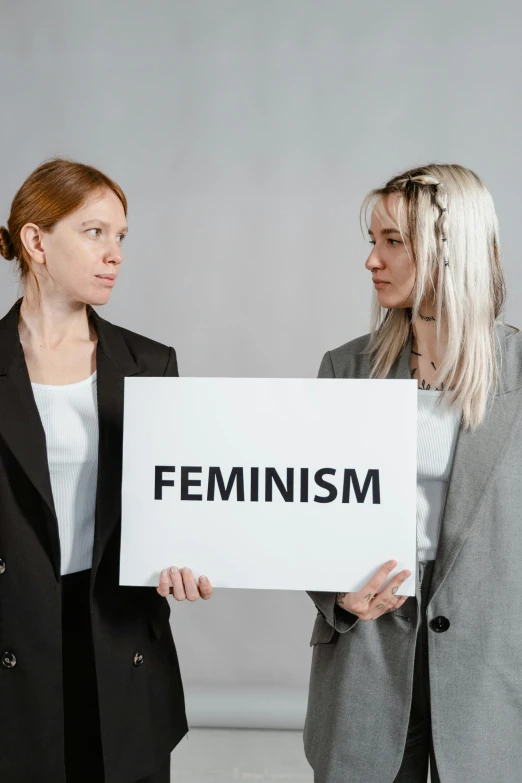 two women holding a sign that says feminism, an album cover, trending on unsplash, transparent, profile image, profile picture, business