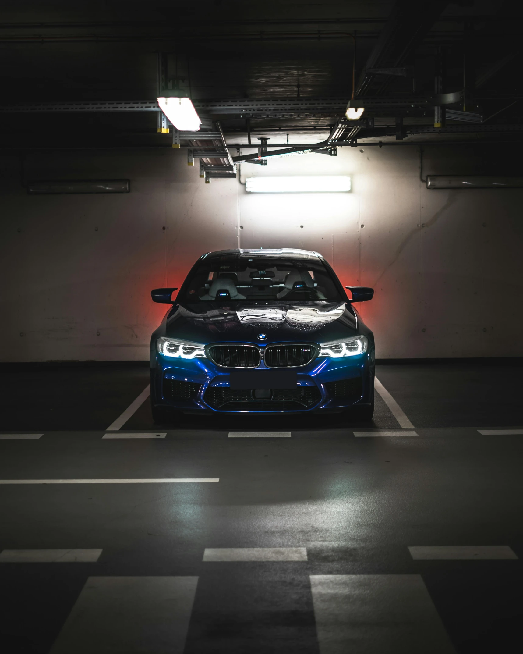 a blue bmw parked in a parking garage, a hologram, by Adam Marczyński, pexels contest winner, bright headlights, lgbtq, frontal pose, race car