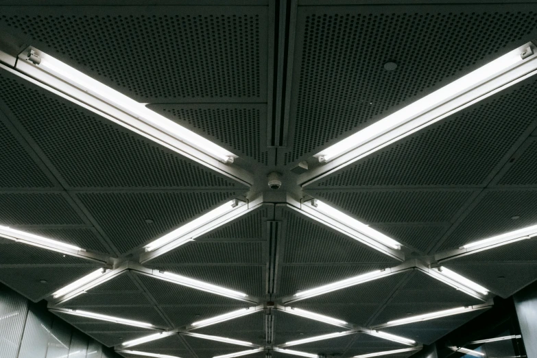 a group of people riding on top of an escalator, pexels contest winner, light and space, office ceiling panels, black. airports, volumetric lighting - h 7 6 8, metal joints